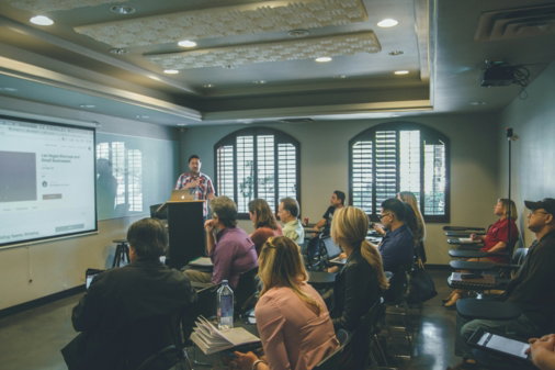 a group of people in a room with a projector screen