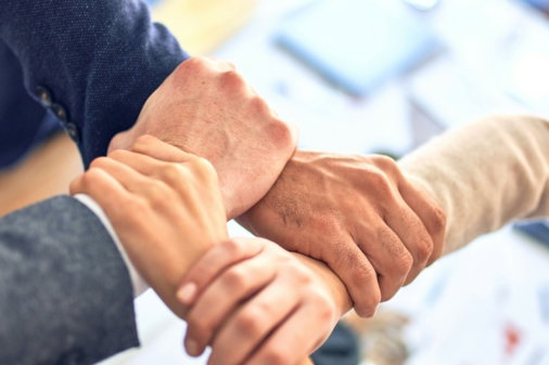 team members gripping wrists in unity gesture
